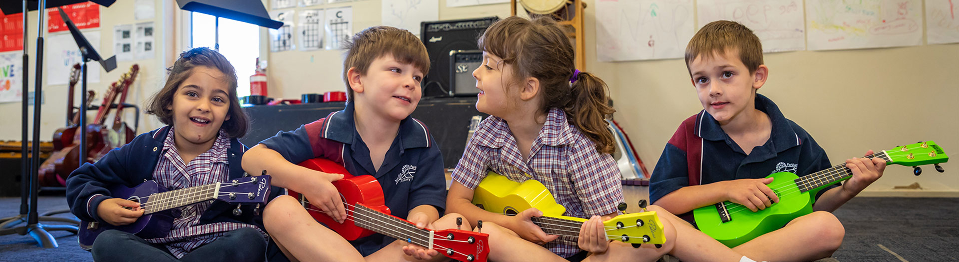 primary school students in music class playing ukuleles
